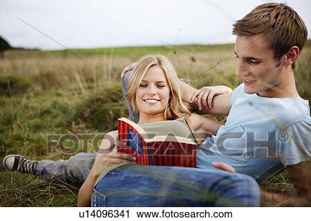 Young couple laying together in nature View Large Photo Image Stock Image - Young couple laying together in nature. Fotosearch