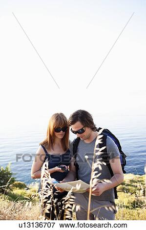 Stock Photo - Young couple looking at compass. Fotosearch