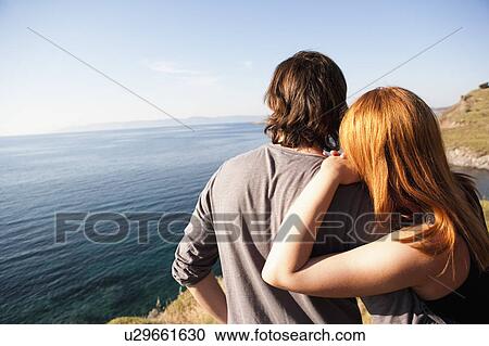 Stock Image - Young couple looking at horizon. Fotosearch