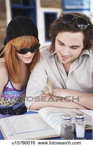 Stock Photograph - Young couple reading menu close up. Fotosearch