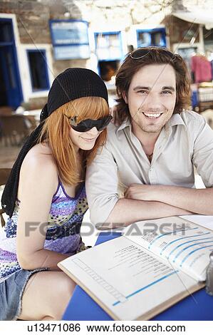 Stock Photograph - Young couple reading menu. Fotosearch