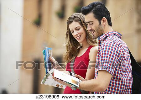 Young couple referring to guidebook View Large Photo Image Stock Photography - Young couple referring to guidebook. Fotosearch