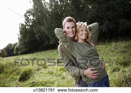 Stock Image - Young couple standing in nature. Fotosearch
