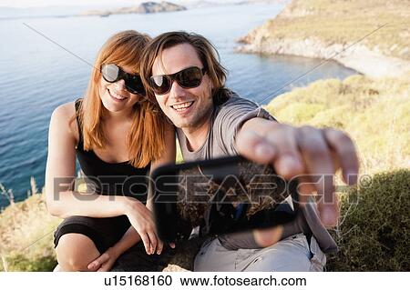 Young couple taking self portrait View Large Photo Image Stock Image - Young couple taking self portrait. Fotosearch