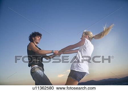 Stock Image - Young cple twirl outside fun. Fotosearch