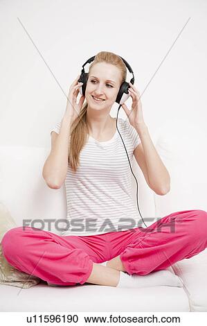 Young female listening to music View Large Photo Image Stock Image - Young female listening to music. Fotosearch