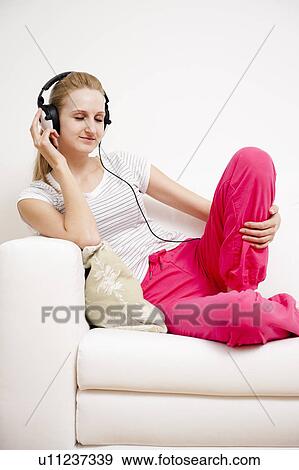 Young female listening to music View Large Photo Image Stock Photo - Young female listening to music. Fotosearch