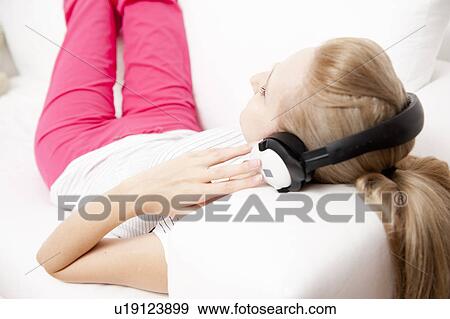 Young female listening to music View Large Photo Image Stock Photo - Young female listening to music. Fotosearch