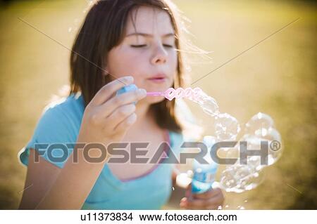 Picture - Young girl blowing bubbles. Fotosearch