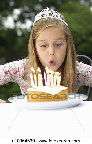Young girl blowing candles out on cake View Large Photo Image Stock Photo - Young girl blowing candles out on cake. Fotosearch