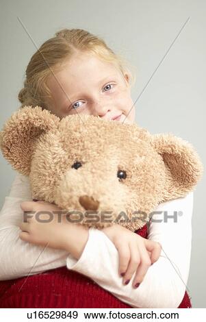 Young girl cuddling teddy bear View Large Photo Image Stock Photo - Young girl cuddling teddy bear. Fotosearch