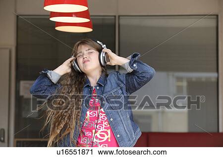 Stock Image - Young girl dancing with headphones. Fotosearch