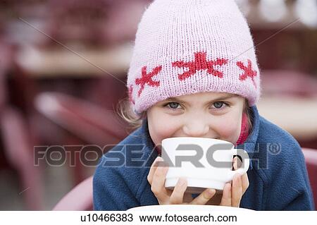 Stock Image - Young girl drinking hot chocolate. Fotosearch