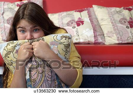 Young girl hiding behind cushion View Large Photo Image Stock Image - Young girl hiding behind cushion. Fotosearch