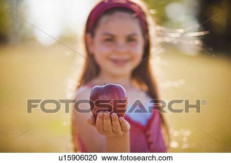 Young girl holding apple View Large Photo Image Stock Image - Young girl holding apple. Fotosearch