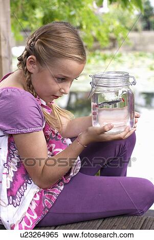 Young girl holding fish in a jar View Large Photo Image Stock Photography - Young girl holding fish in a jar. Fotosearch