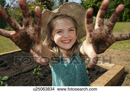 Young girl in garden with muddy hands View Large Photo Image Picture - Young girl in garden with muddy hands. Fotosearch