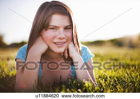 Young girl in grass smiling View Large Photo Image Stock Image - Young girl in grass smiling. Fotosearch