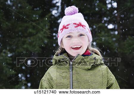Stock Image - Young girl in wooly hat with snow flakes. Fotosearch
