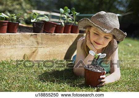 Young girl looking at vegetable plant View Large Photo Image Stock Image - Young girl looking at vegetable plant. Fotosearch
