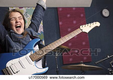 Young girl playing guitar in studio View Large Photo Image Stock Photo - Young girl playing guitar in studio. Fotosearch