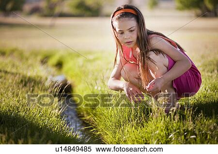 Stock Photography - Young girl playing in creek. Fotosearch