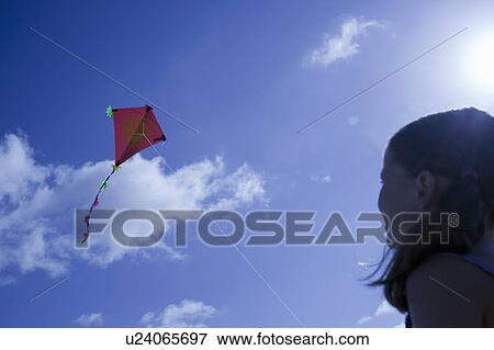 Stock Photo - Young girl playing with a kite. Fotosearch