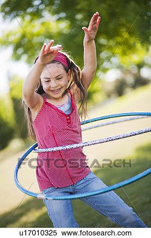 Stock Photography - Young girl playing with hula hoop. Fotosearch