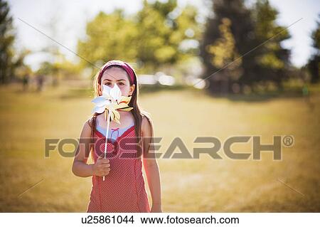 Young girl playing with wind wheel View Large Photo Image Picture - Young girl playing with wind wheel. Fotosearch