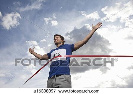 Young man crossing finish line View Large Photo Image Stock Photo - Young man crossing finish line. Fotosearch