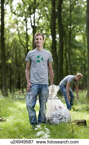 Young man holding trash bag in nature View Large Photo Image Stock Photo - Young man holding trash bag in nature. Fotosearch
