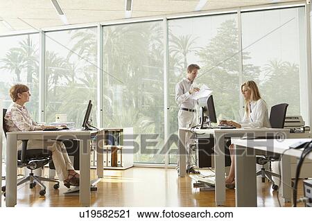 Young man in office with colleagues View Large Photo Image Stock Image - Young man in office with colleagues. Fotosearch