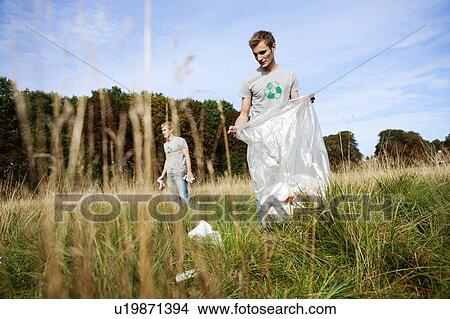 Young man picking up trash in nature View Large Photo Image Picture - Young man picking up trash in nature. Fotosearch