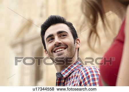 Young man smiling at his girlfriend View Large Photo Image Stock Photo - Young man smiling at his girlfriend. Fotosearch