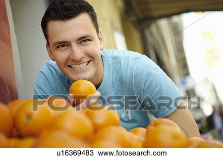 Stock Image - Young person in a fruit stall. Fotosearch