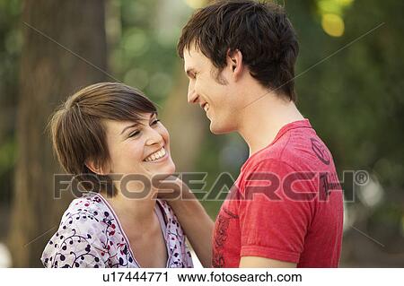 Stock Image - Young romantic couple in a park. Fotosearch