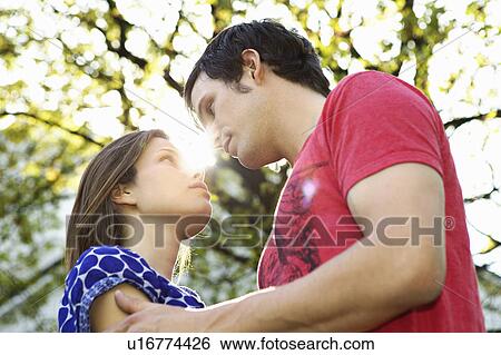 Stock Photograph - Young romantic couple in a park. Fotosearch