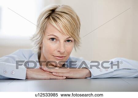 Stock Photography - Young woman at desk. Fotosearch