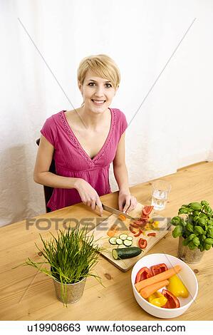 Stock Image - Young Woman at Home Preparing Food. Fotosearch