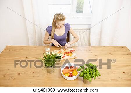 Stock Photo - Young Woman at Home Preparing Food. Fotosearch