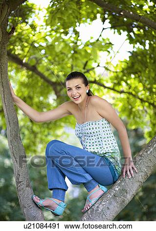 Young woman climbing tree View Large Photo Image Stock Image - Young woman climbing tree. Fotosearch
