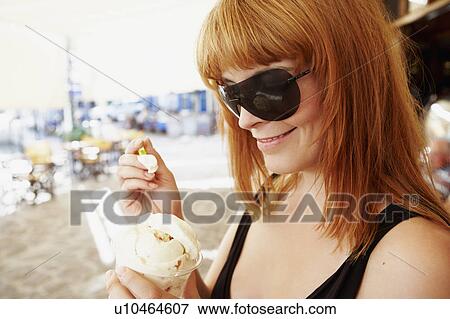 Stock Photo - Young woman eating ice cream. Fotosearch