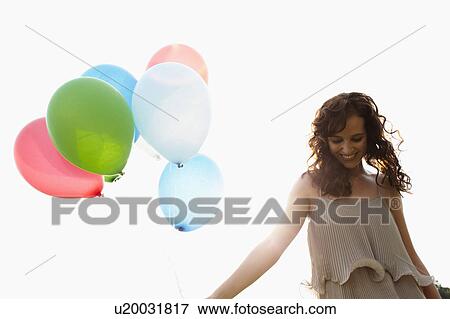 Stock Photo - Young woman holding air balloons. Fotosearch