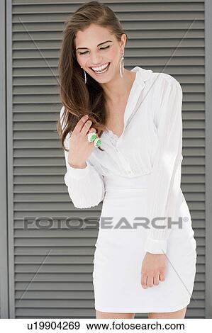Young woman in front of window shutter View Large Photo Image Stock Photo - Young woman in front of window shutter. Fotosearch