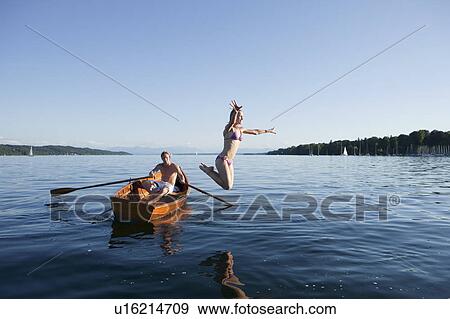 Young woman jumping off a row boat View Large Photo Image Stock Photo - Young woman jumping off a row boat. Fotosearch