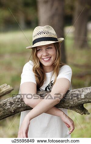 Stock Photo - Young woman leaning againg tree. Fotosearch