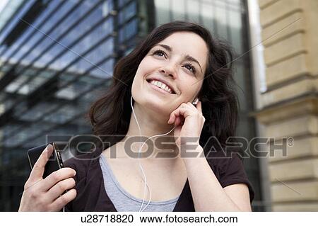 Young woman listening to music View Large Photo Image Stock Image - Young woman listening to music. Fotosearch