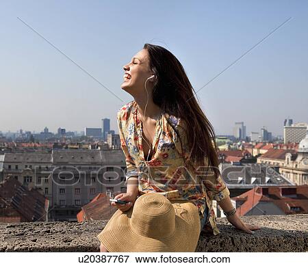 Young woman listening to music View Large Photo Image Stock Photo - Young woman listening to music. Fotosearch