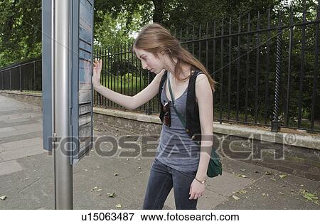 Young woman looking at bus time table View Large Photo Image Stock Photo - Young woman looking at bus time table. Fotosearch