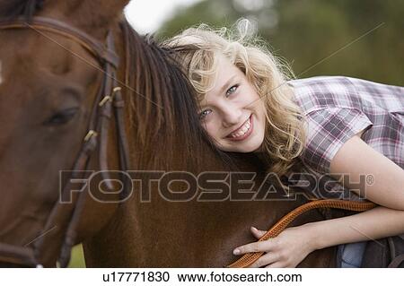 Stock Image - Young woman on a horse. Fotosearch